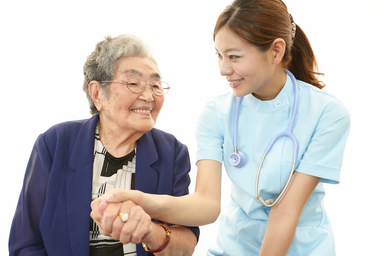 看護師と患者が握手をしている写真